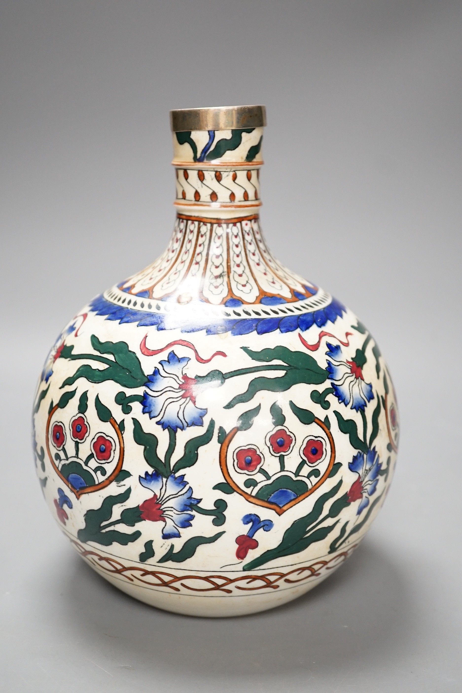 A Continental pottery bottle vase, in Iznik style, ground down with white metal mount. 20cm tall.